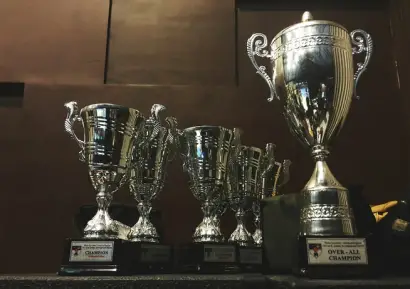 Seis troféus em uma prateleira.
